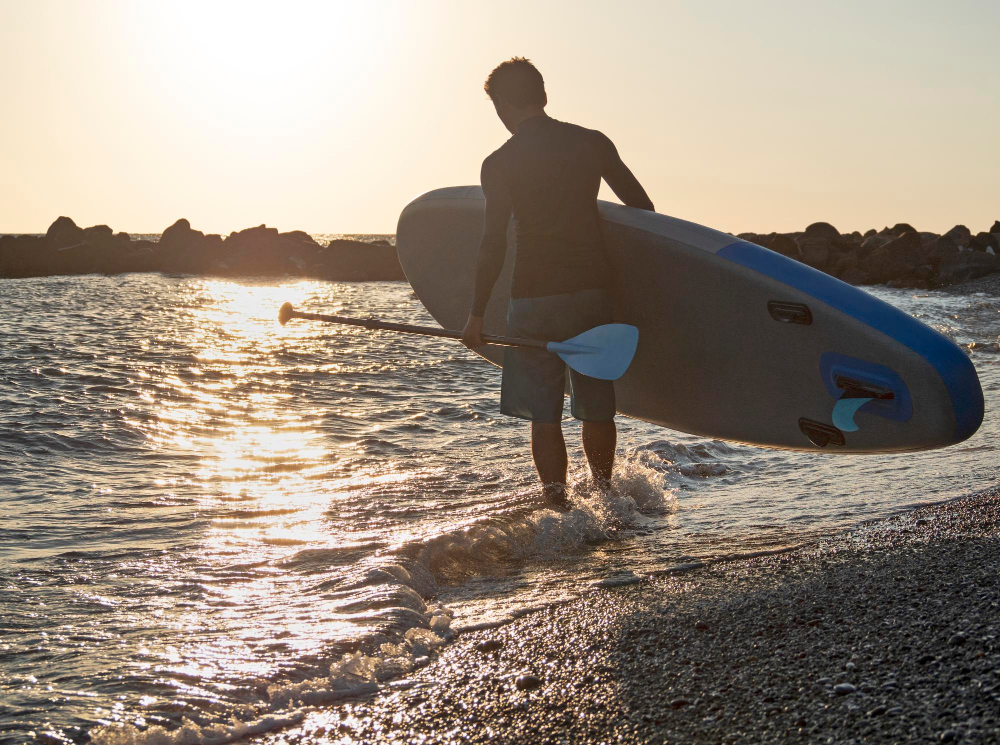 man-with-sup-paddle-beach-go-surfing-golden-sunset-background